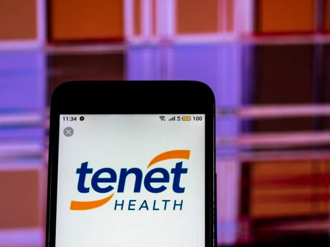 A phone with the Tenet Health logo on its screen.