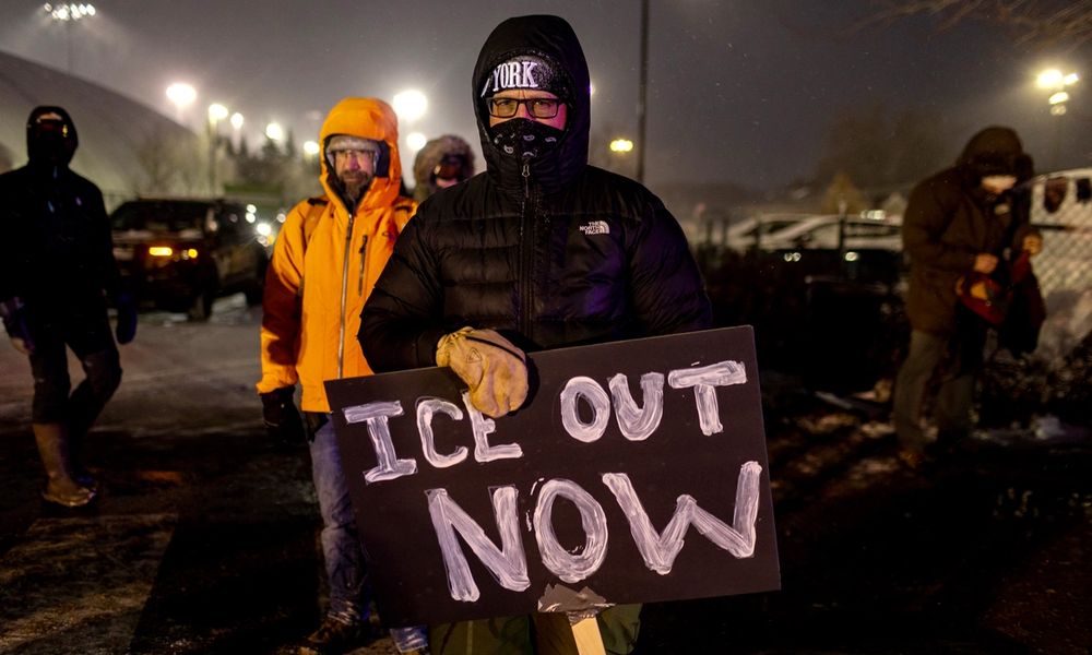 A protester with an anti-ICE sign, stands outside of the Henry Bishop Whipple Federal building on January 18, 2026 in Minneapolis, Minnesota.