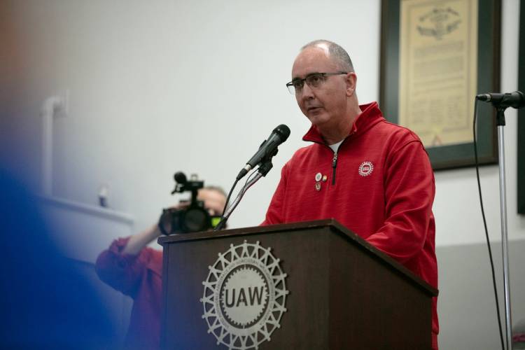 UAW President Shawn Fain speaks from a podium.