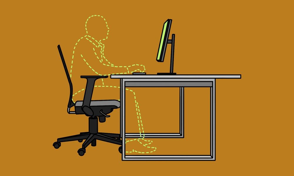 The outline of a worker at an empty office desk