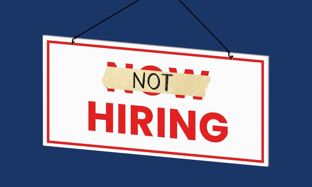 Now Hiring sign with piece of tape over "now" with "not" written on it.