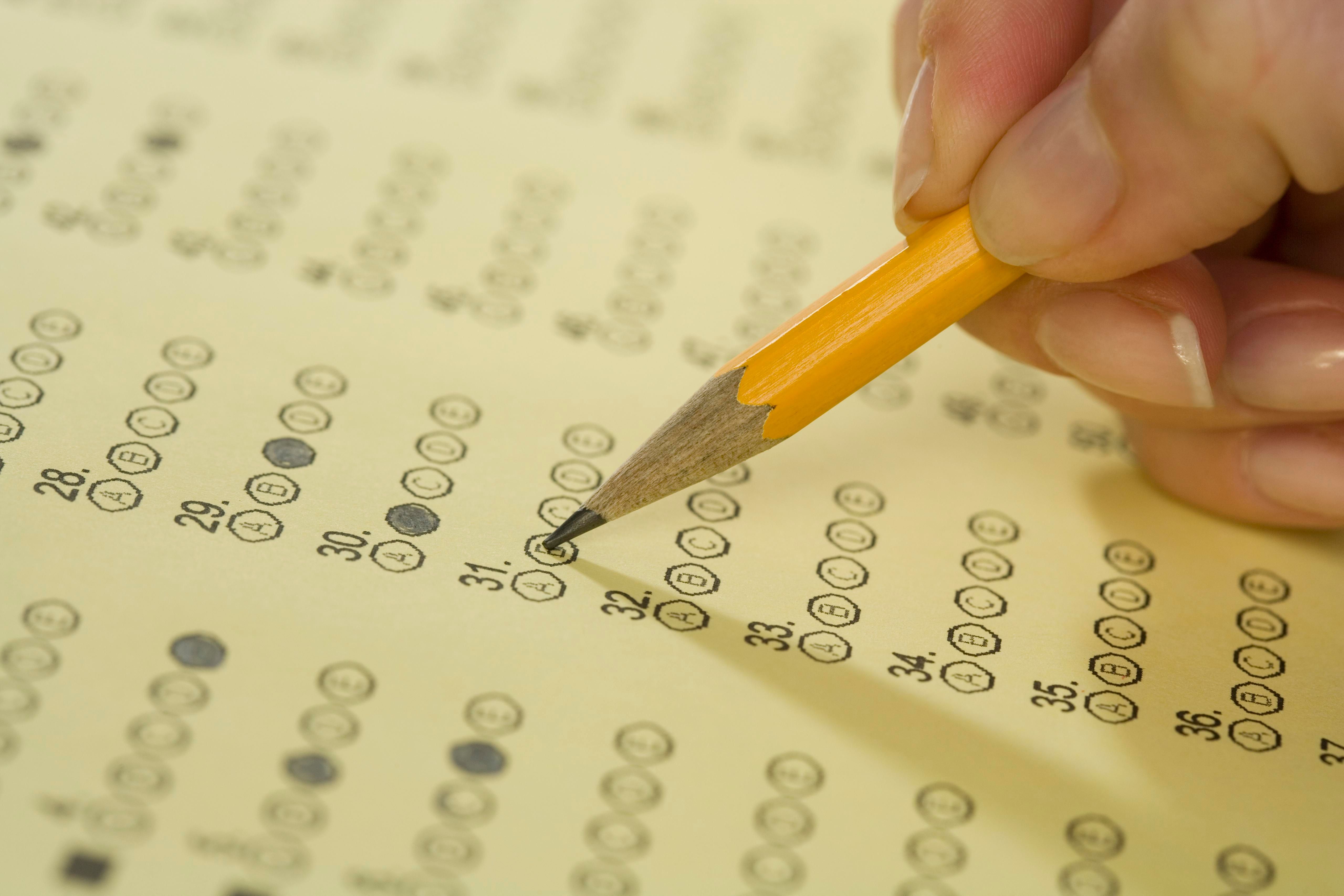 Close up of a hand filling in a multiple choice bubble sheet. (Credit: Tetra Images/Getty Images)