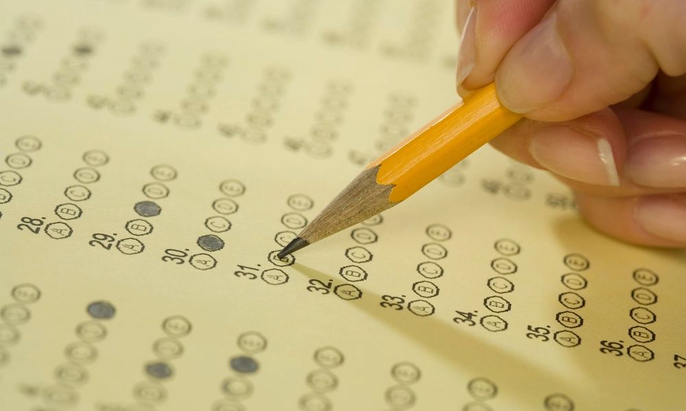 Close up of a hand filling in a multiple choice bubble sheet. (Credit: Tetra Images/Getty Images)