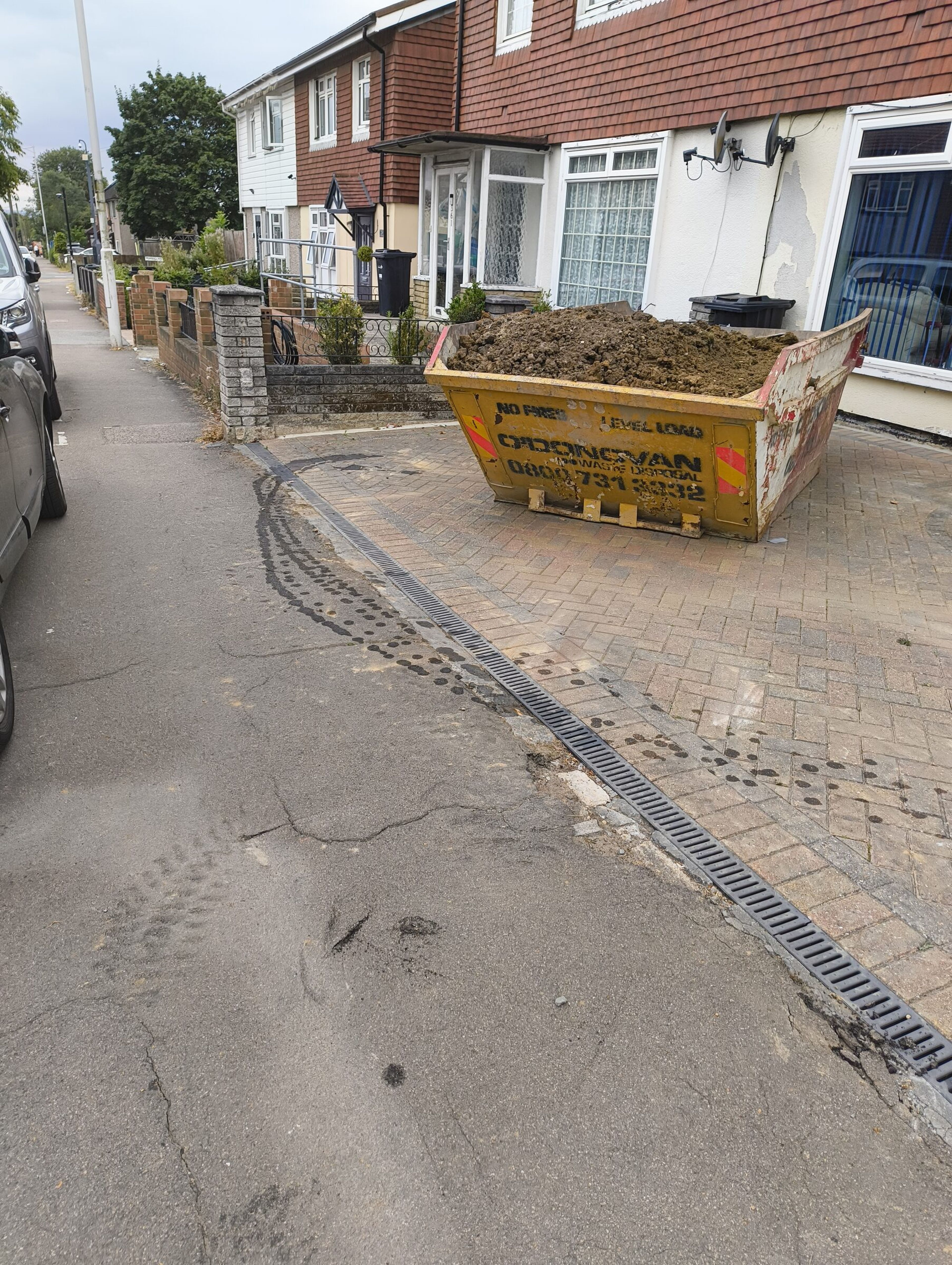 Skip filled with excavated soil on a Chigwell rear extension site.