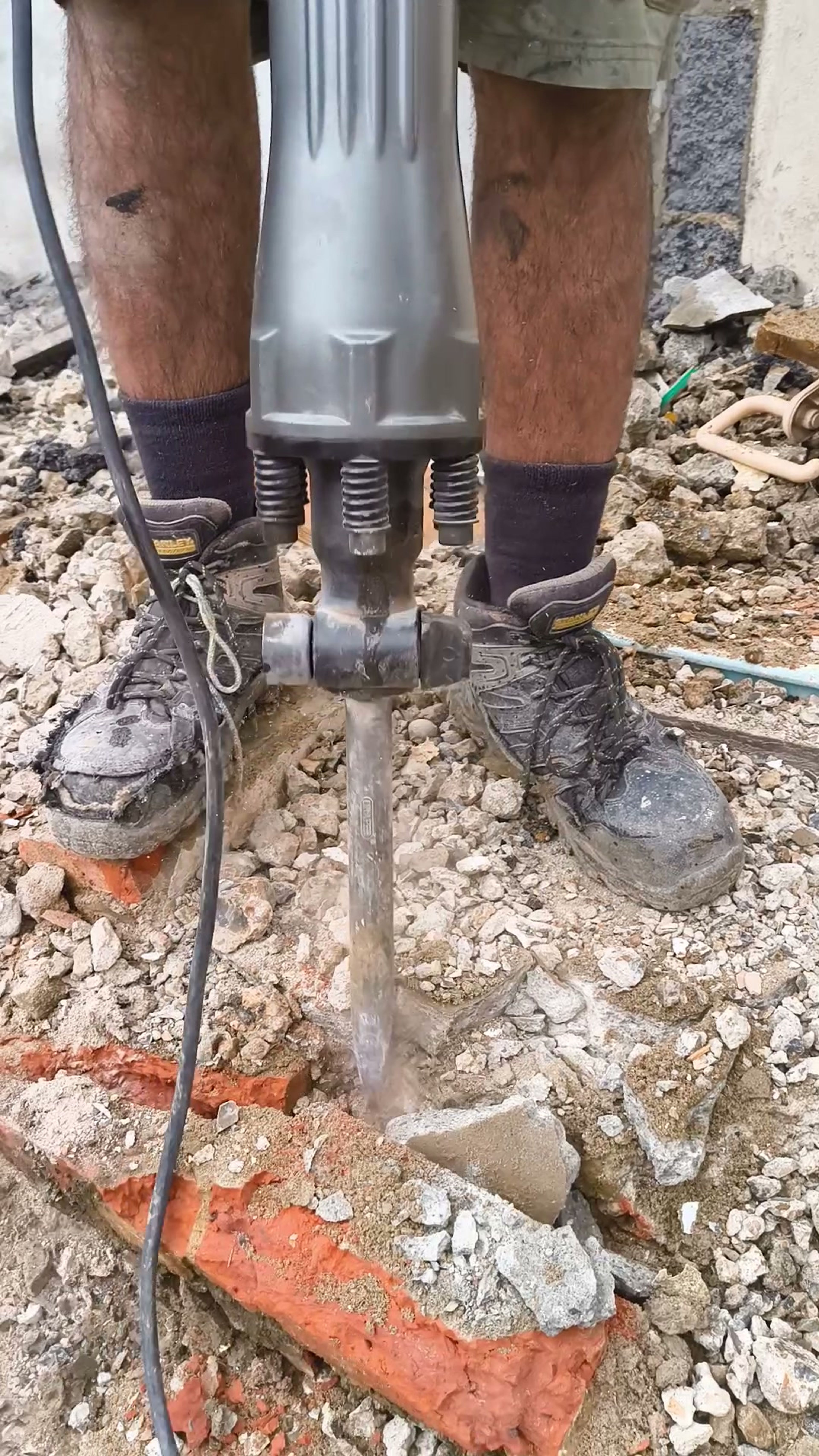 Close-up of a breaker bit cutting through brick rubble in Chigwell