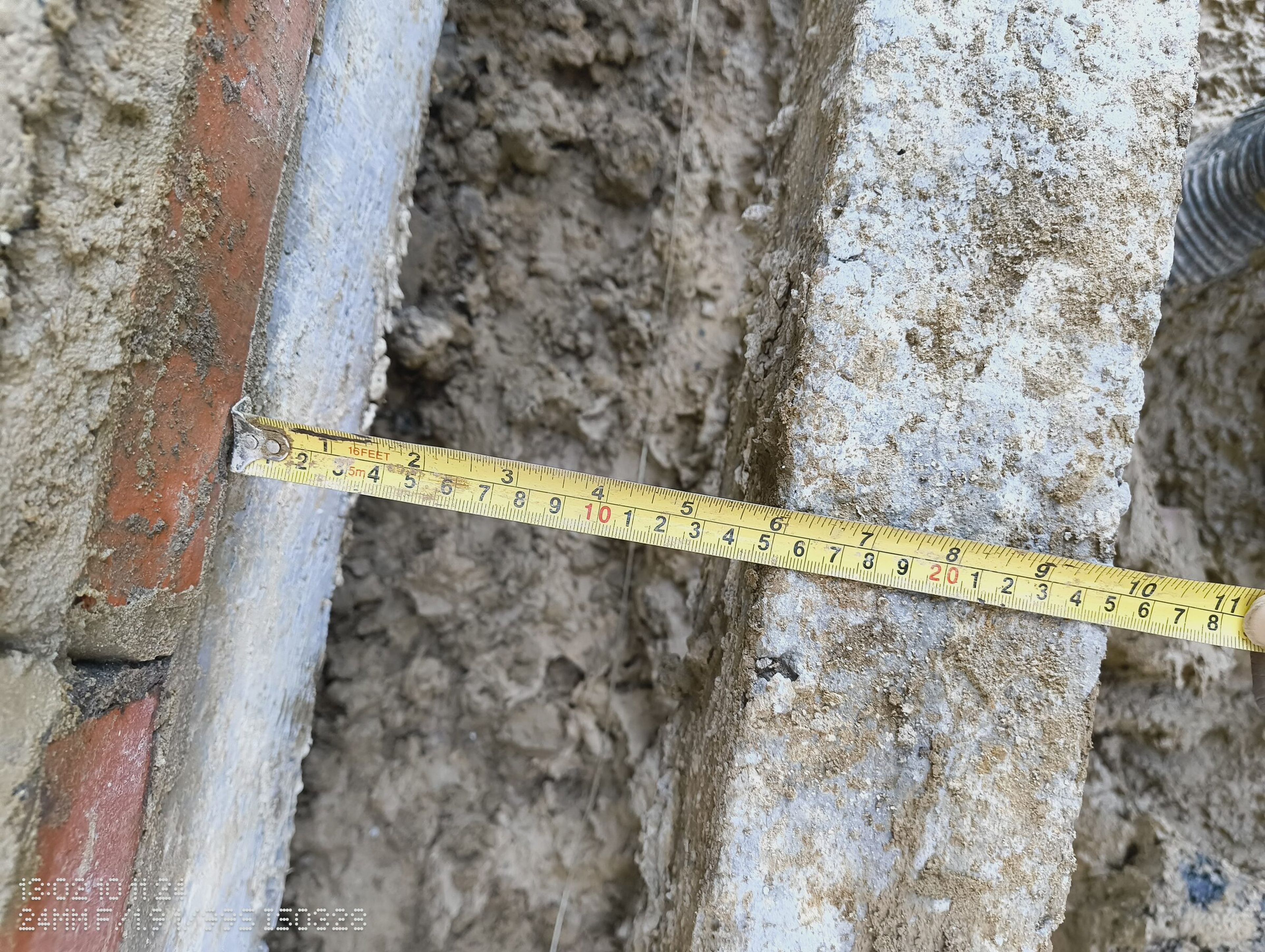 Tape measure across the cavity where the new wall meets the house.