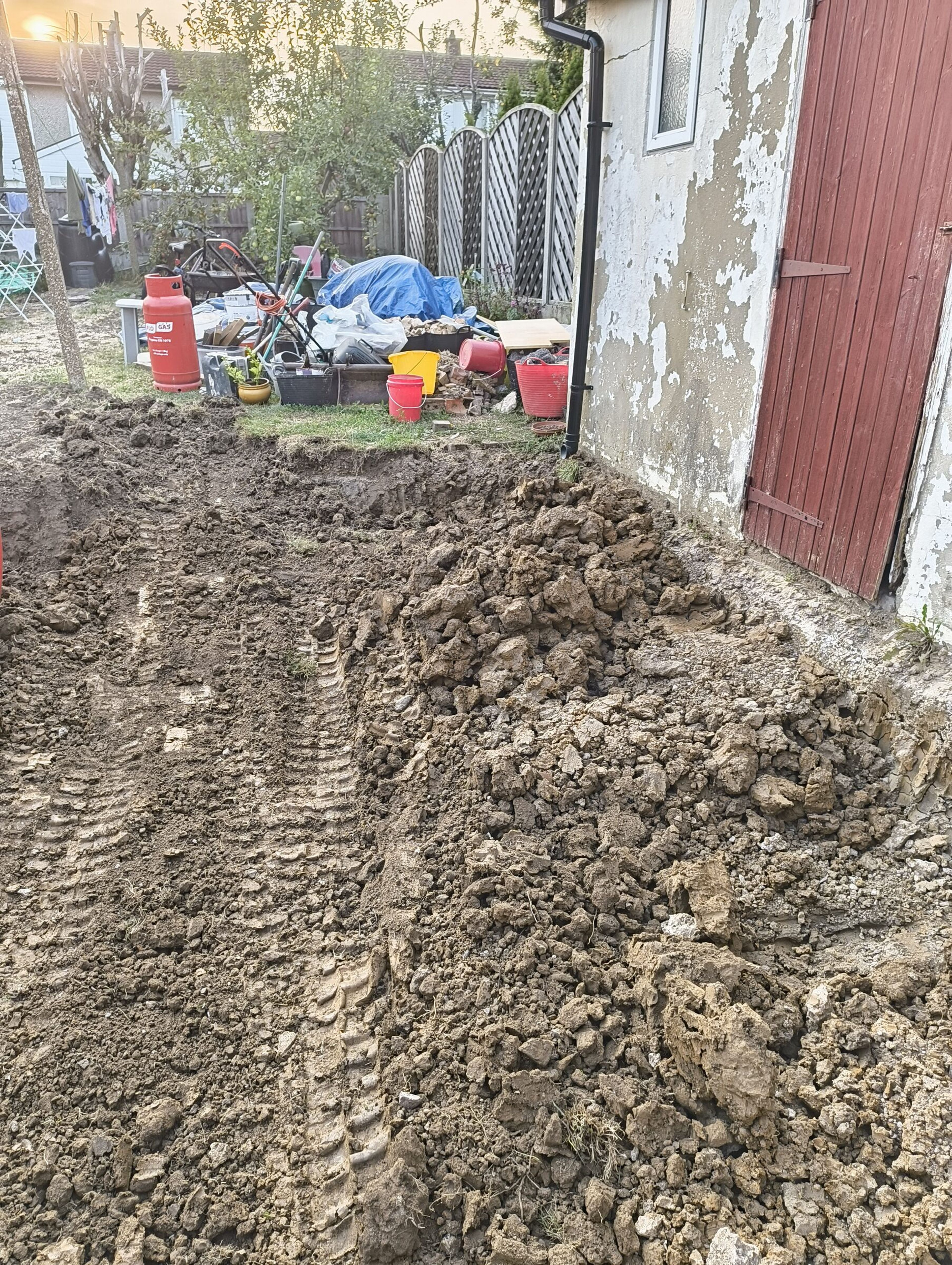 Cleared rear garden with mini digger track marks after excavation for a Chigwell rear extension.