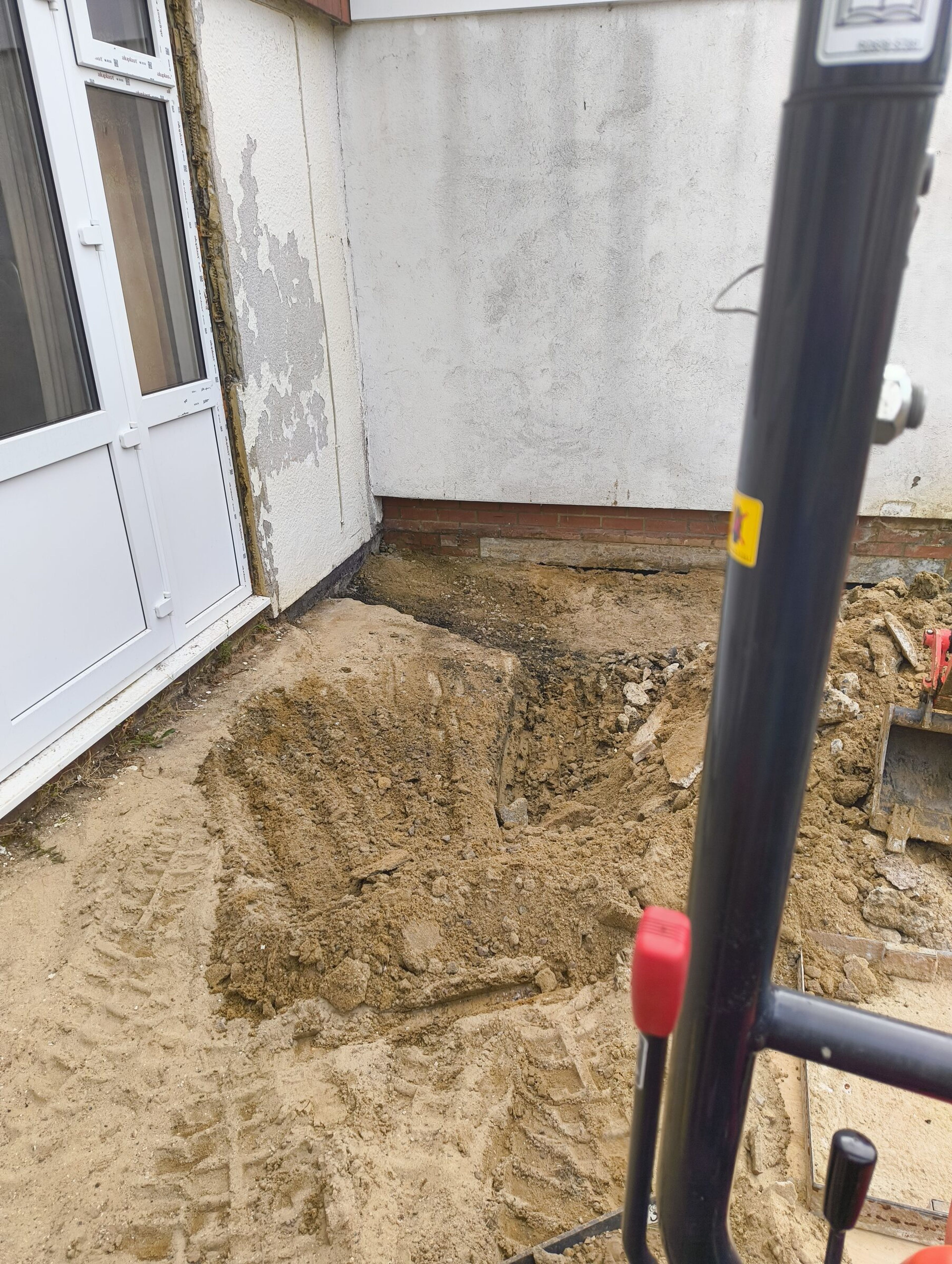 Mini digger levelling excavated ground for a Chigwell rear extension.