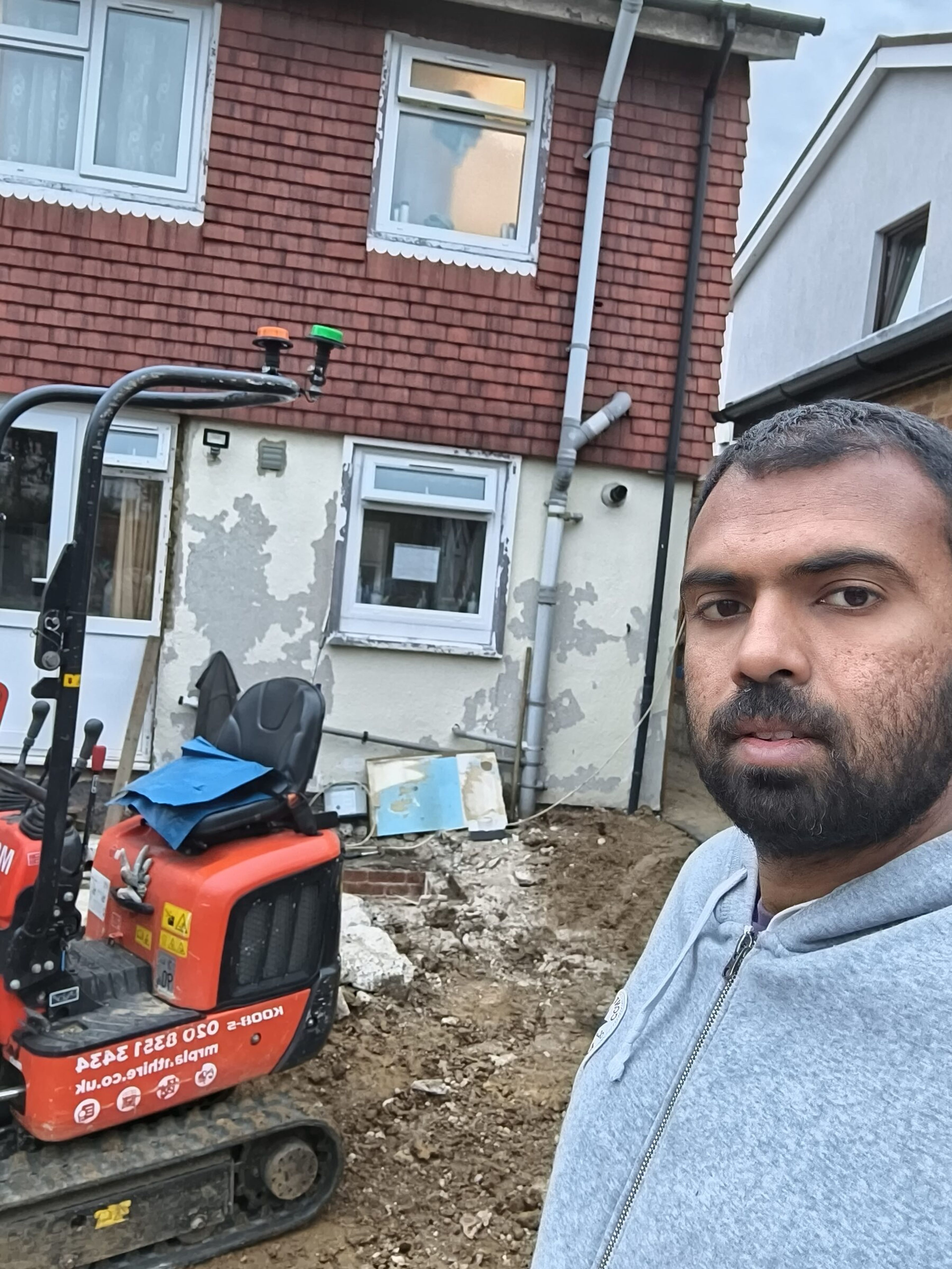 Krishan, digger driver, with a mini digger on a Chigwell rear extension site.