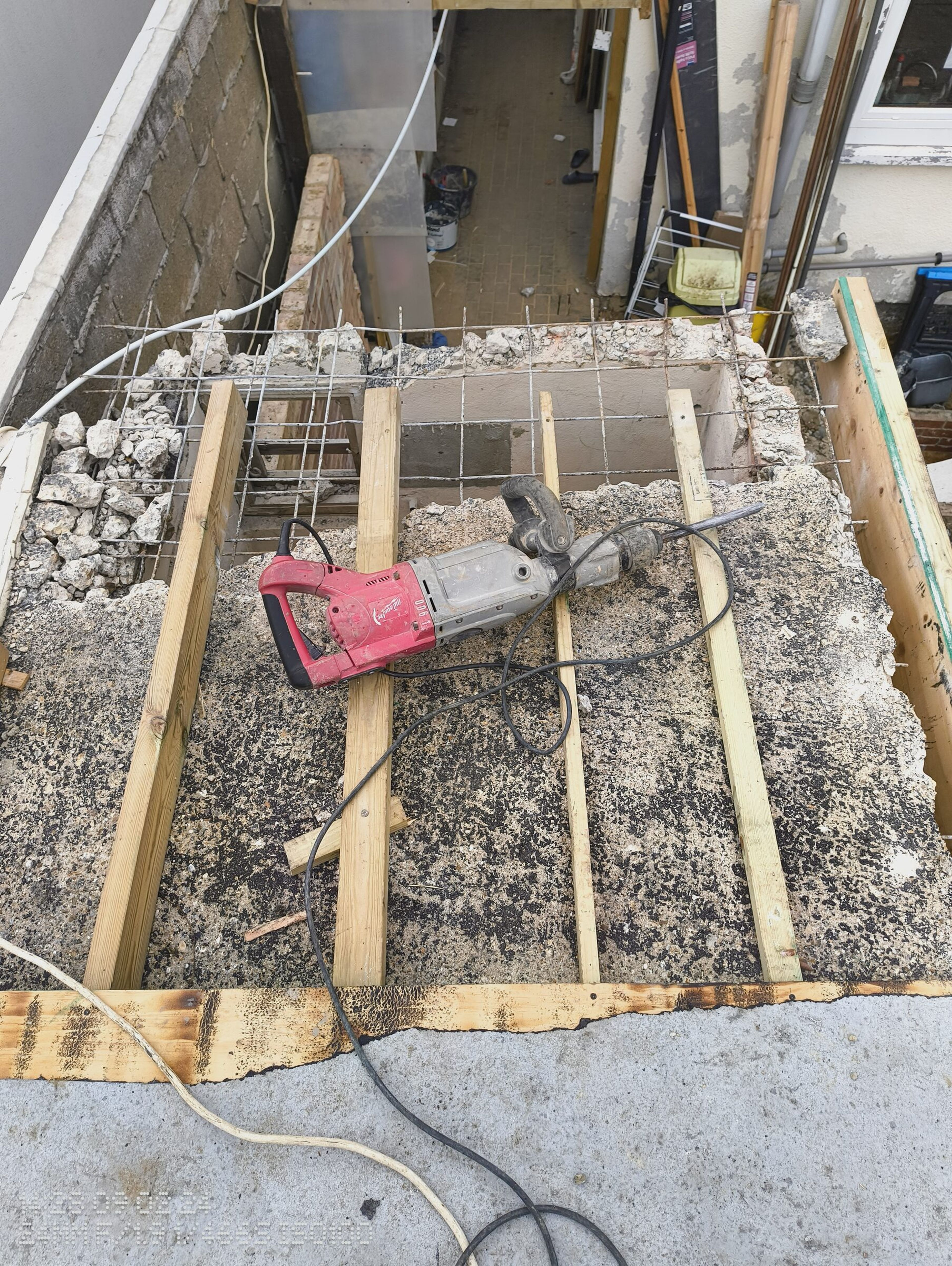 Breaker resting on the roof joists where the concrete slab has been cut back to the steel mesh.