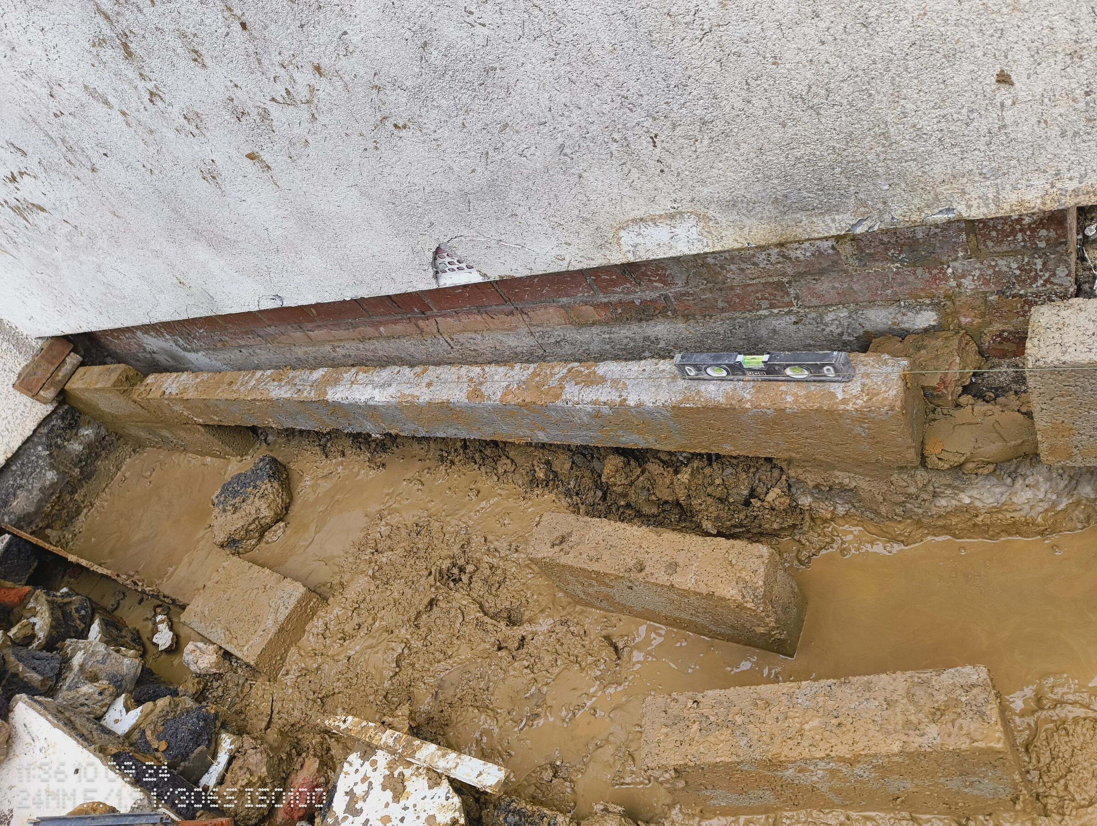Blockwork courses sitting in standing water at the base of the rear extension trench.