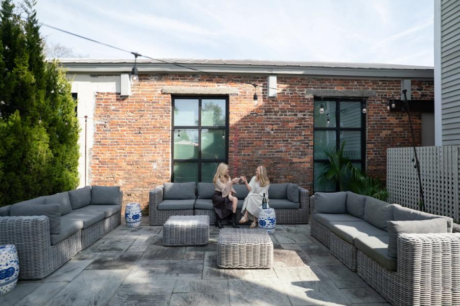 Charleston vacation rental courtyard with outdoor seating, brick architecture, and private gathering space by Respite & Revelry Co.
