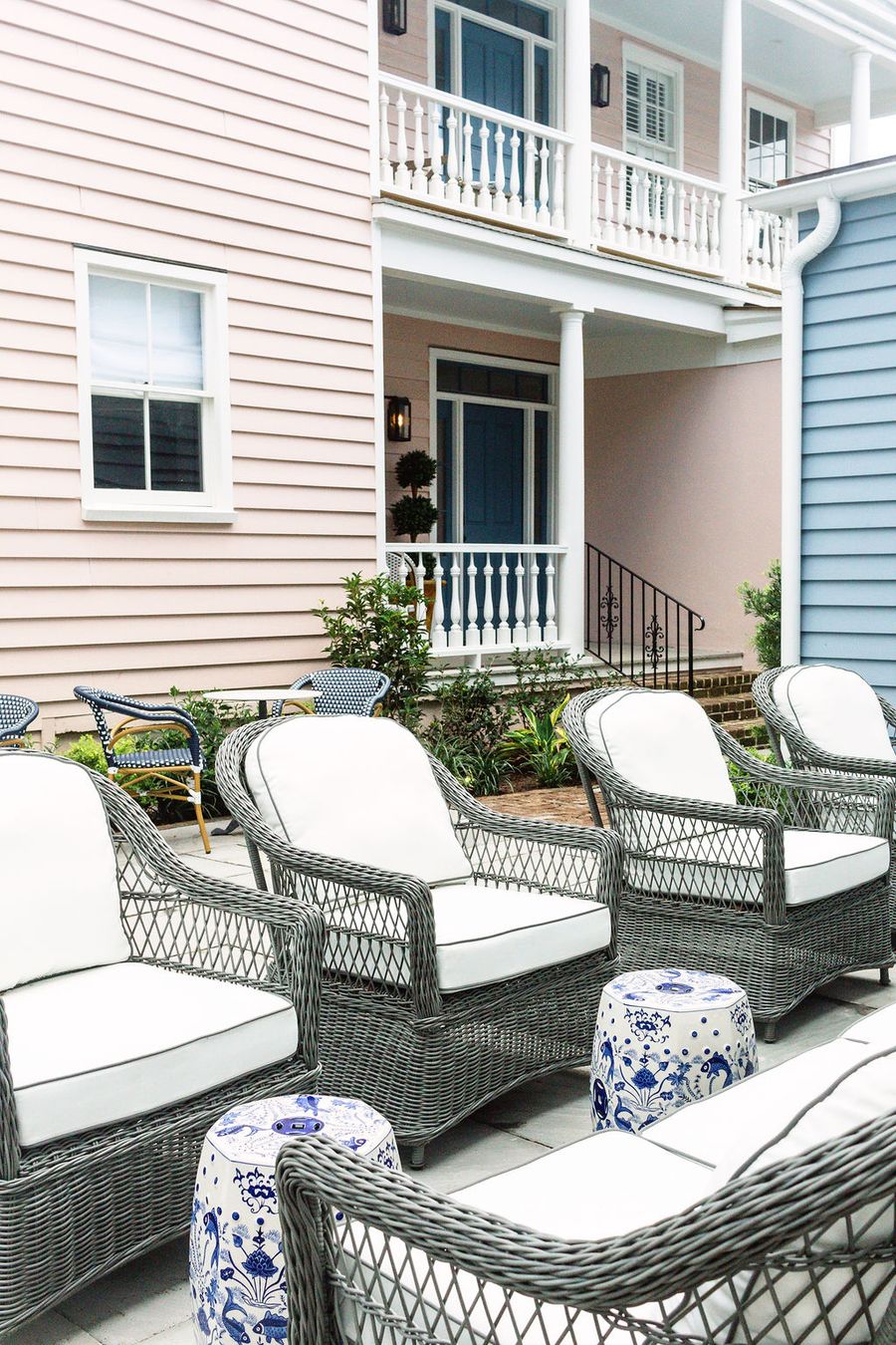 Outdoor seating area with wicker lounge chairs on the piazza of a historic Charleston SC vacation rental