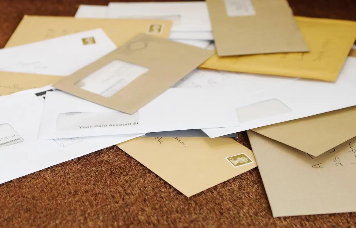 Pile of business mail envelopes representing the need for a virtual mailbox service
