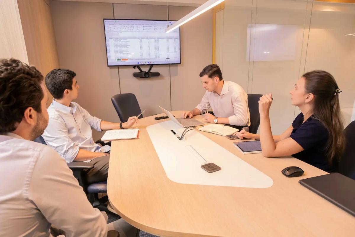 Healthcare billing team reviewing financial data in a meeting room, analyzing the ROI of electronic check deposits on revenue cycle performance