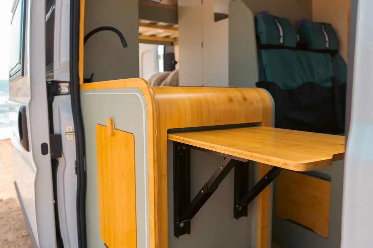 Mesa y asiento interior de Van Makasi junto a la puerta lateral.