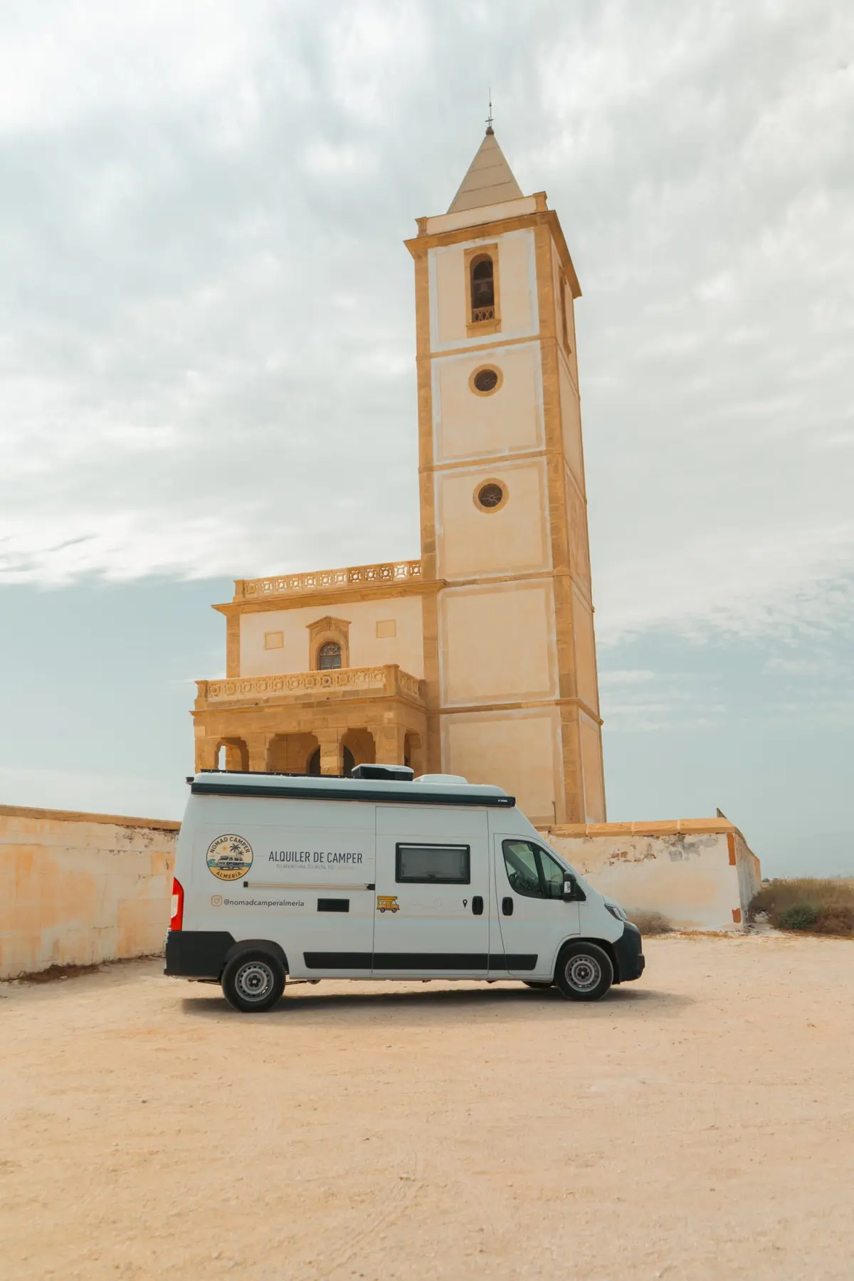 Van Makasi estacionada junto a un faro de la costa de Almería.