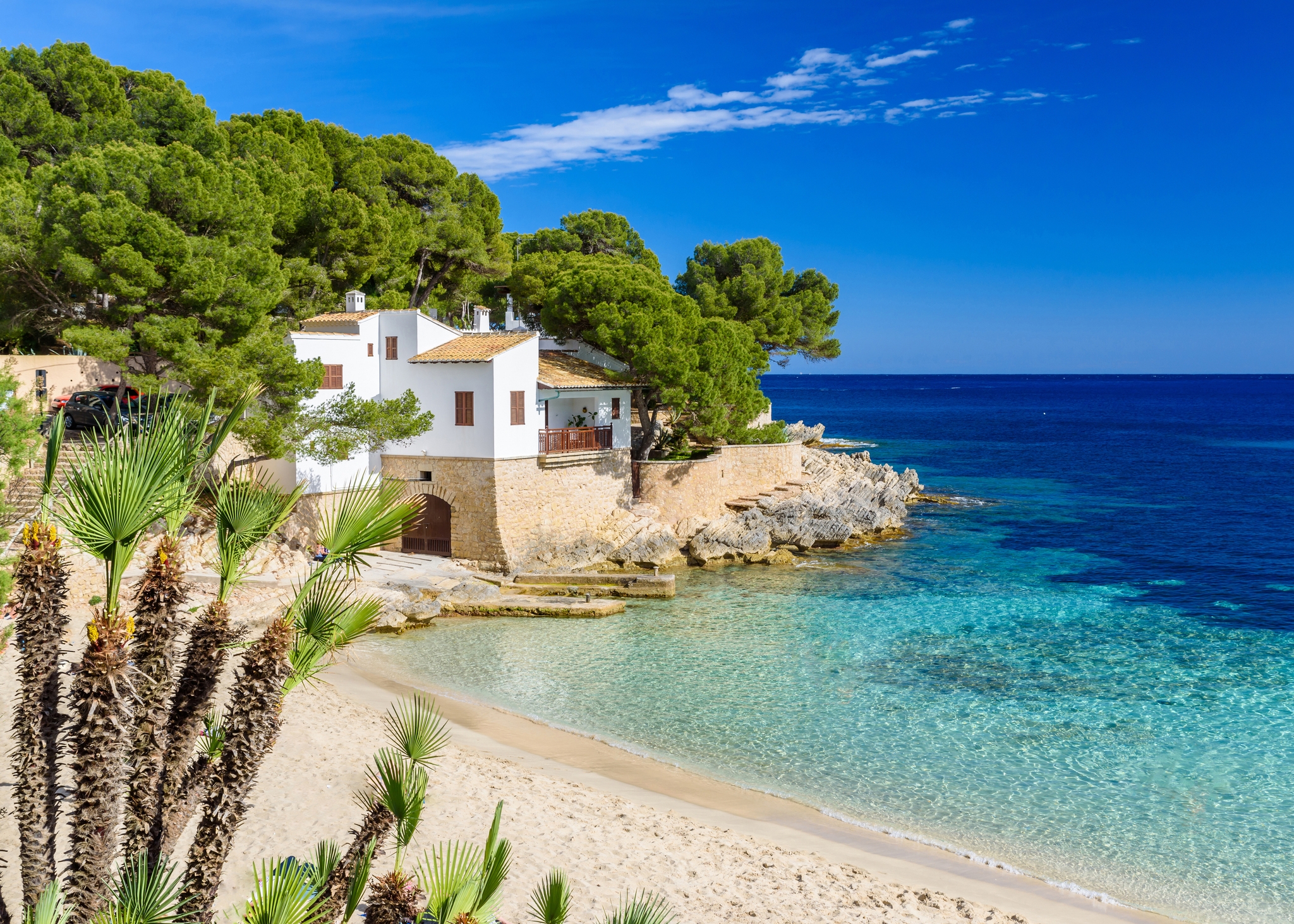 Vitt hus på en klippa vid en sandstrand