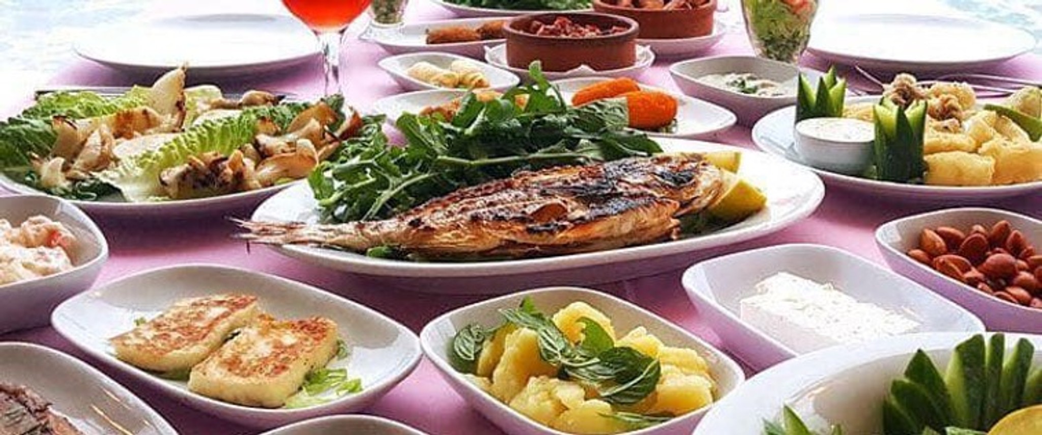 Grillad fisk och andra smårätter på vita fat