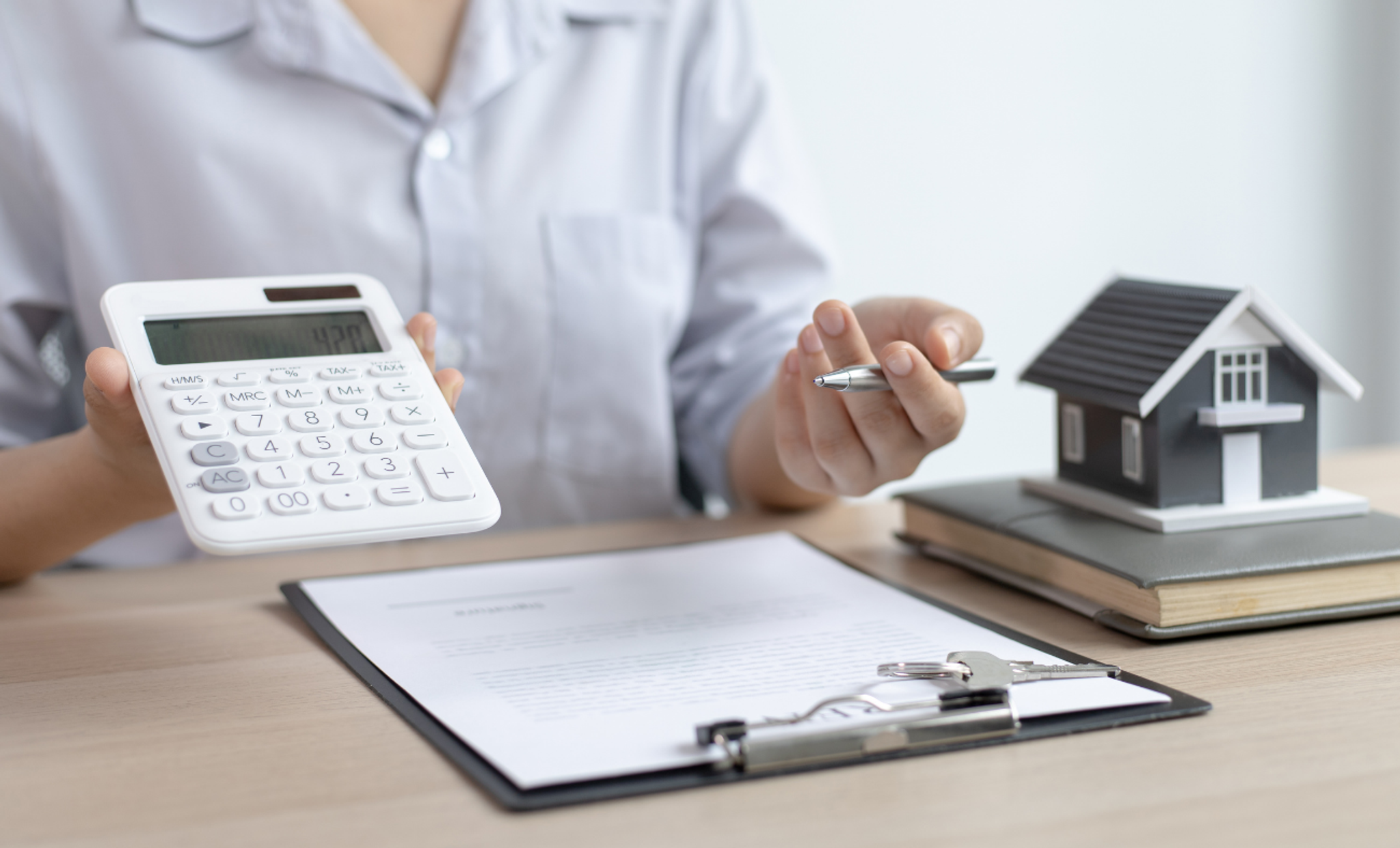 Person som skriver och visar en miniräknare