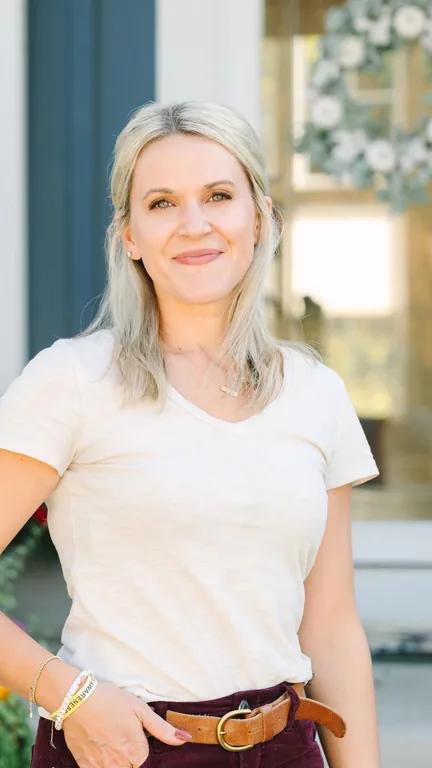 Erin Slivka smiling in a light T-shirt outside a house.