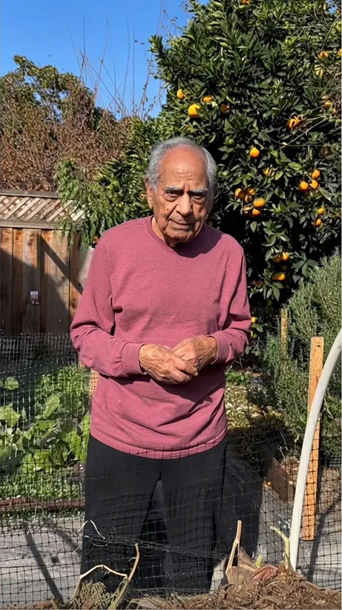 Manohar Sehgal smiling outside in a home garden.