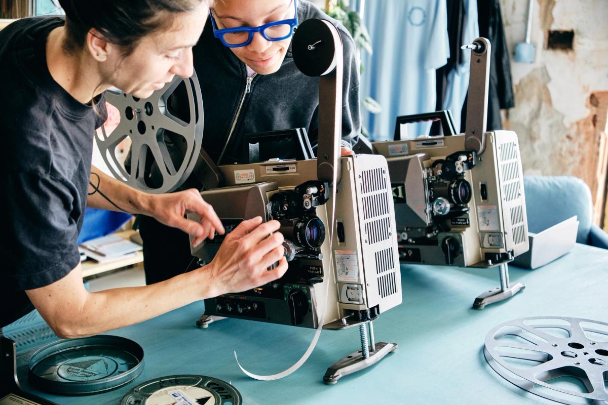a man and a woman are working on a projector .