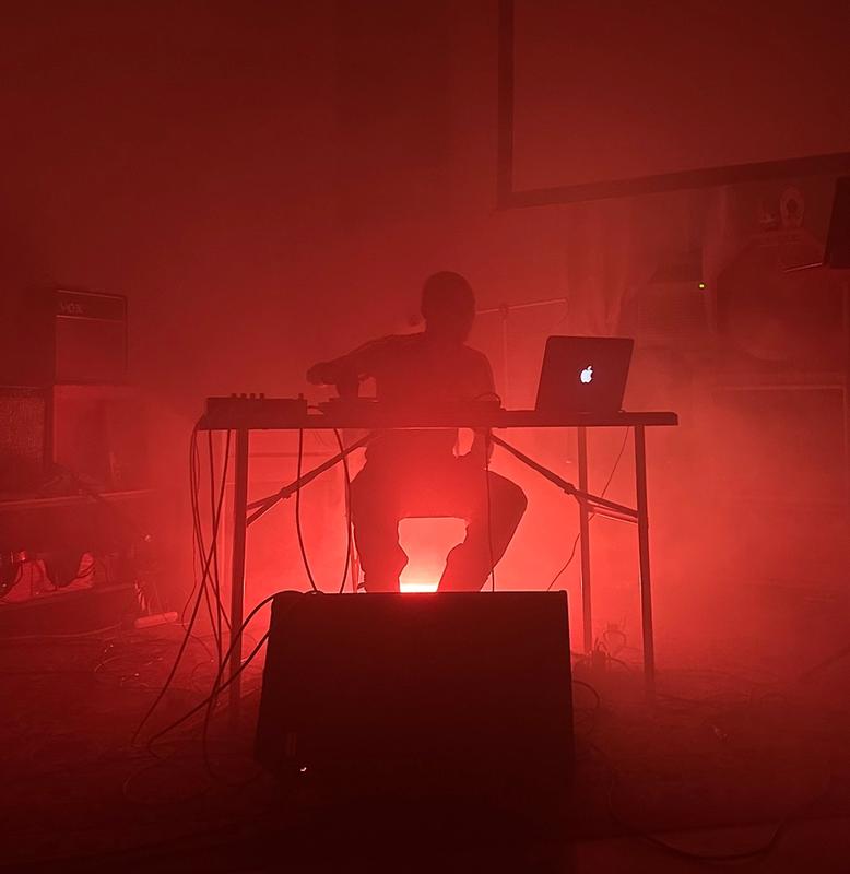 a man is sitting at a desk with a laptop in a dark room .