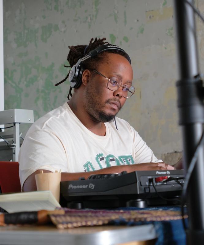 a man is sitting at a table playing a dj set .