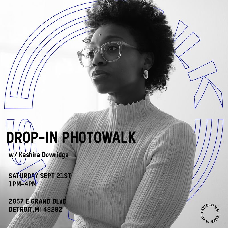 a black and white photo of a woman wearing glasses and a white sweater .