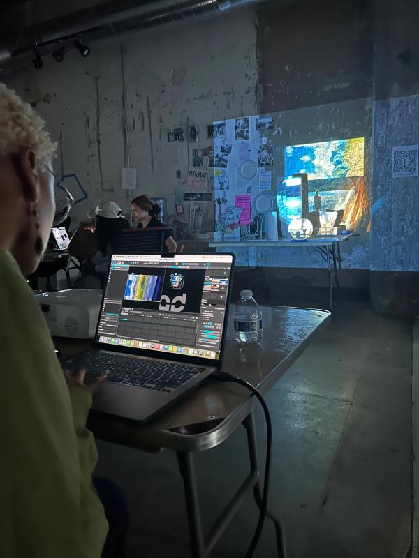 a person sitting in front of a laptop that says ' adobe ' on it
