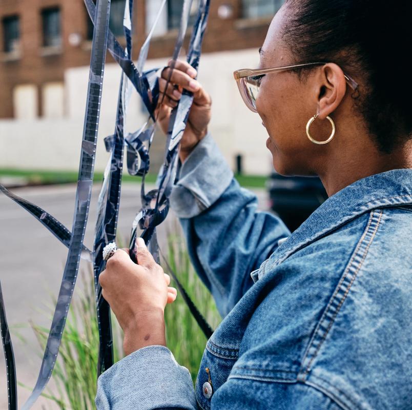 a woman in a denim jacket is holding a roll of film .