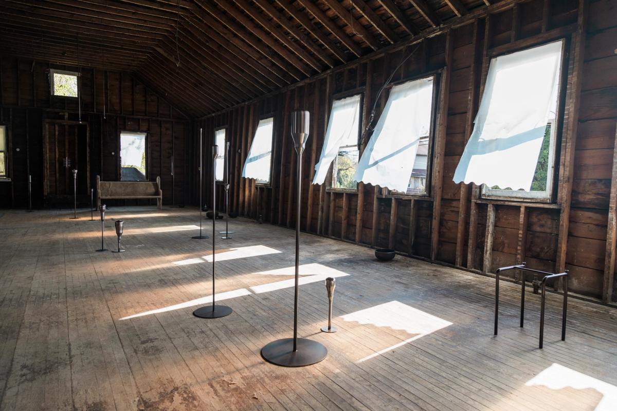 a room with a lot of windows and candles on the floor .