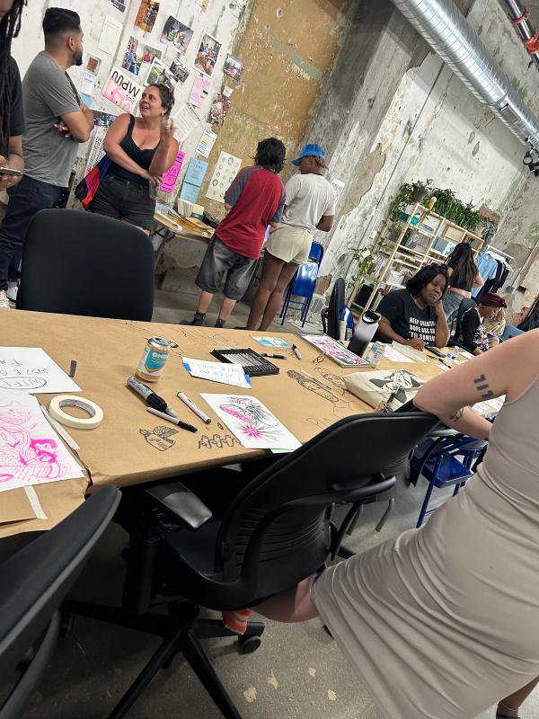 a group of people are sitting around a table with drawings on it .