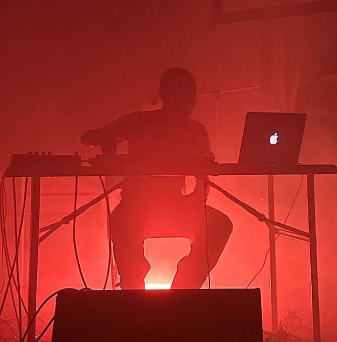 Flyer for XTL: The Audio Workshop, 'Intro to Ableton,' with Kat Nzingha. October 3, 6-8PM and October 4, 2-4PM, at Bulk Space Media Lab, 2857 E. Grand Blvd. The image shows a silhouette of a person at a table with a laptop and audio equipment, bathed in red light.