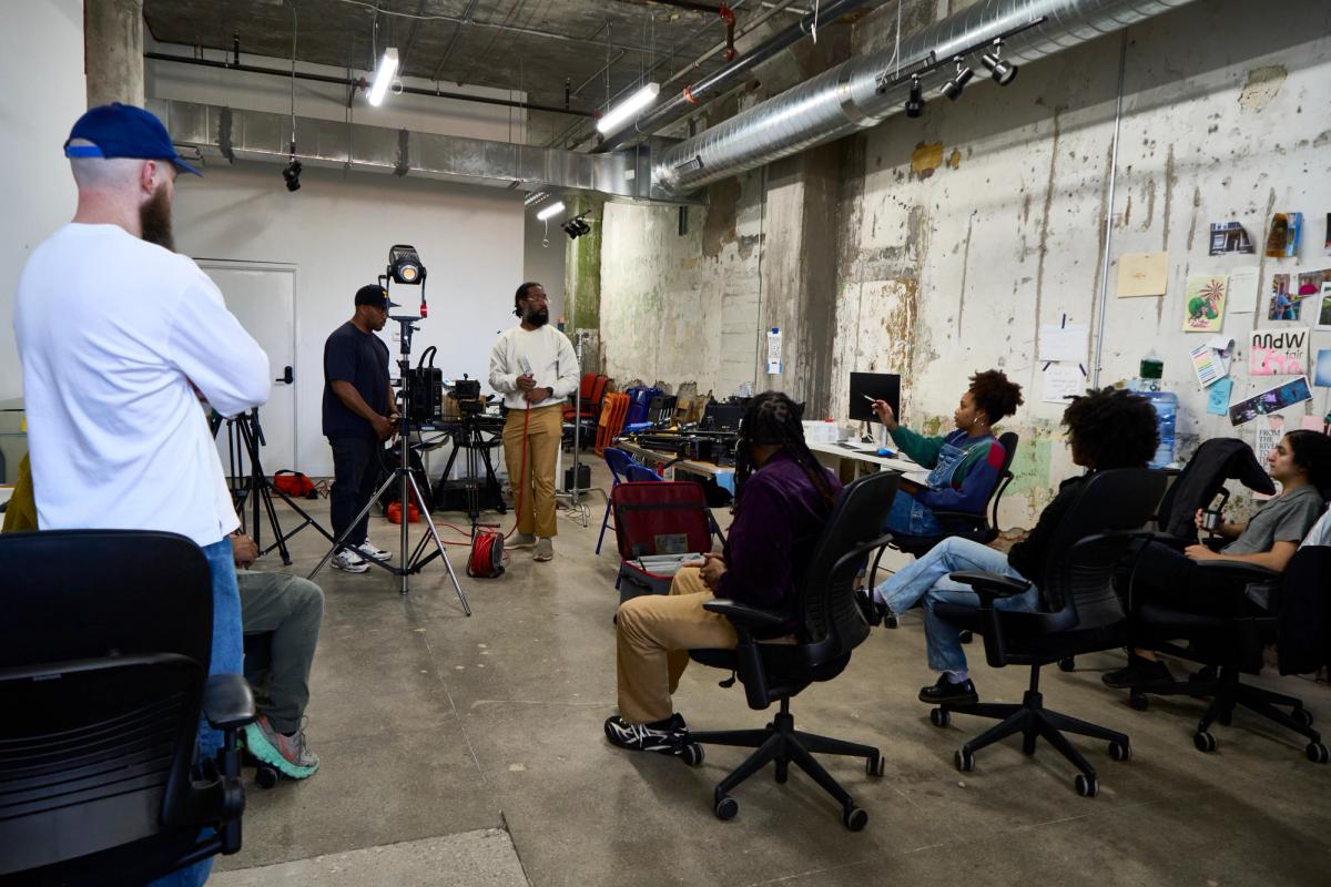 a group of people are sitting in chairs in a room .