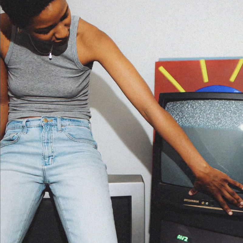 a woman sitting in front of a sylvania tv