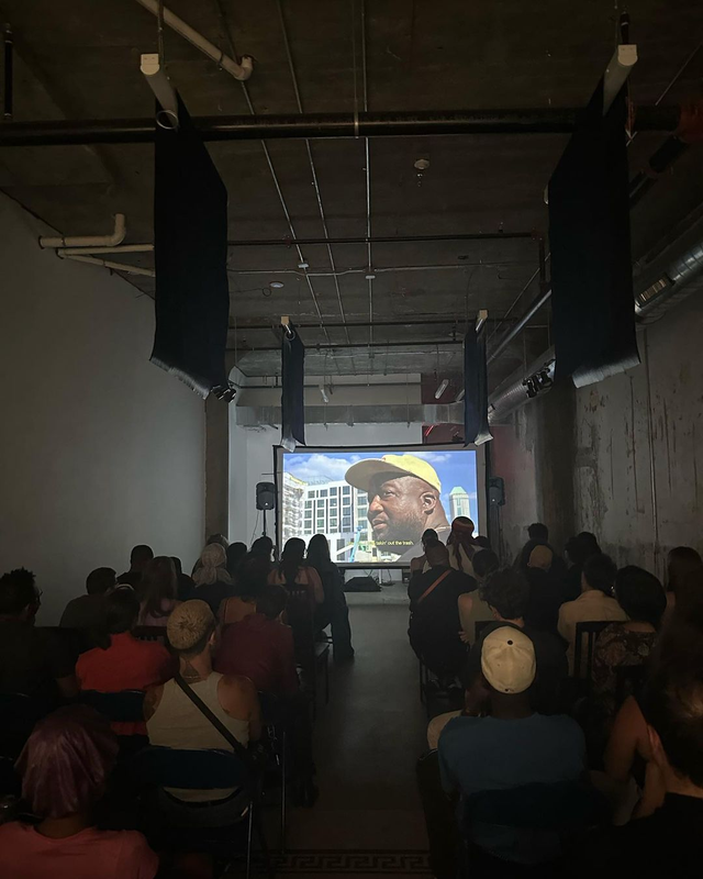 a group of people are watching a movie on a large screen