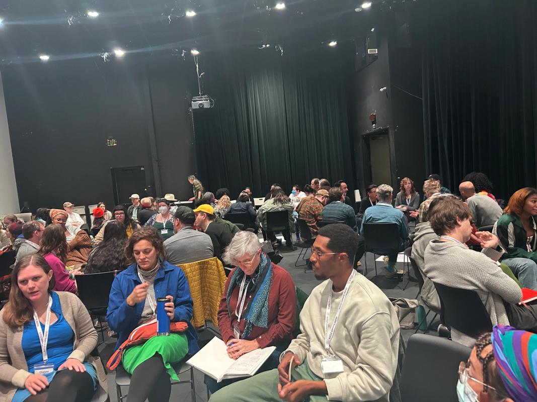 a large group of people are sitting in a large auditorium .