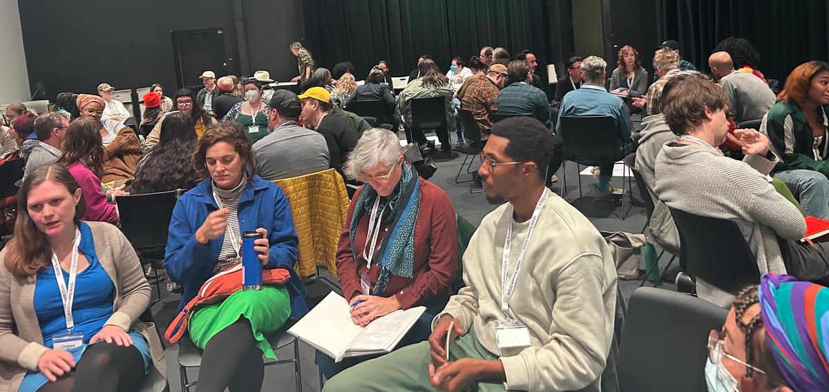 a large group of people are sitting in a large auditorium .