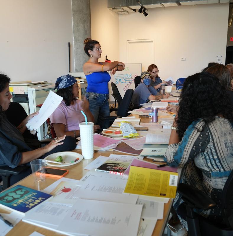 a group of people are sitting around a table in a room .