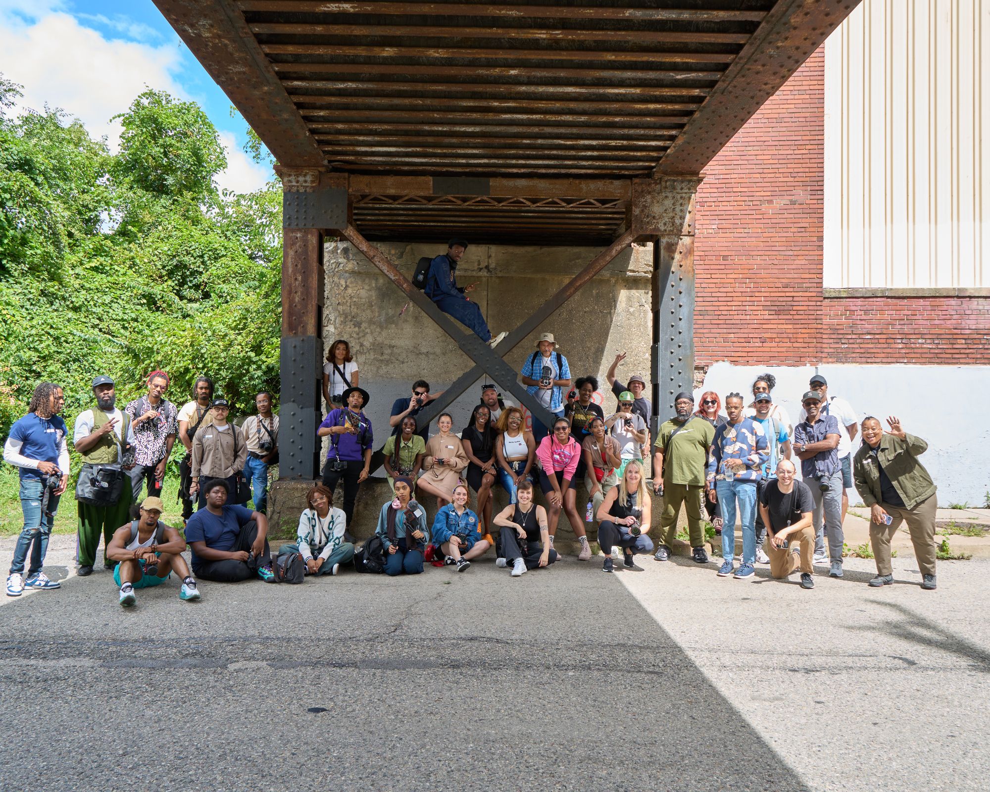 a group of people are posing for a picture under a bridge .