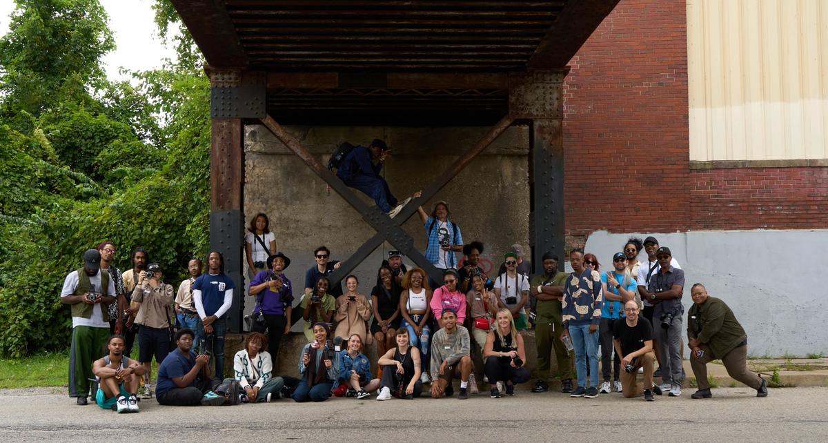 a group of people are posing for a picture under a bridge .