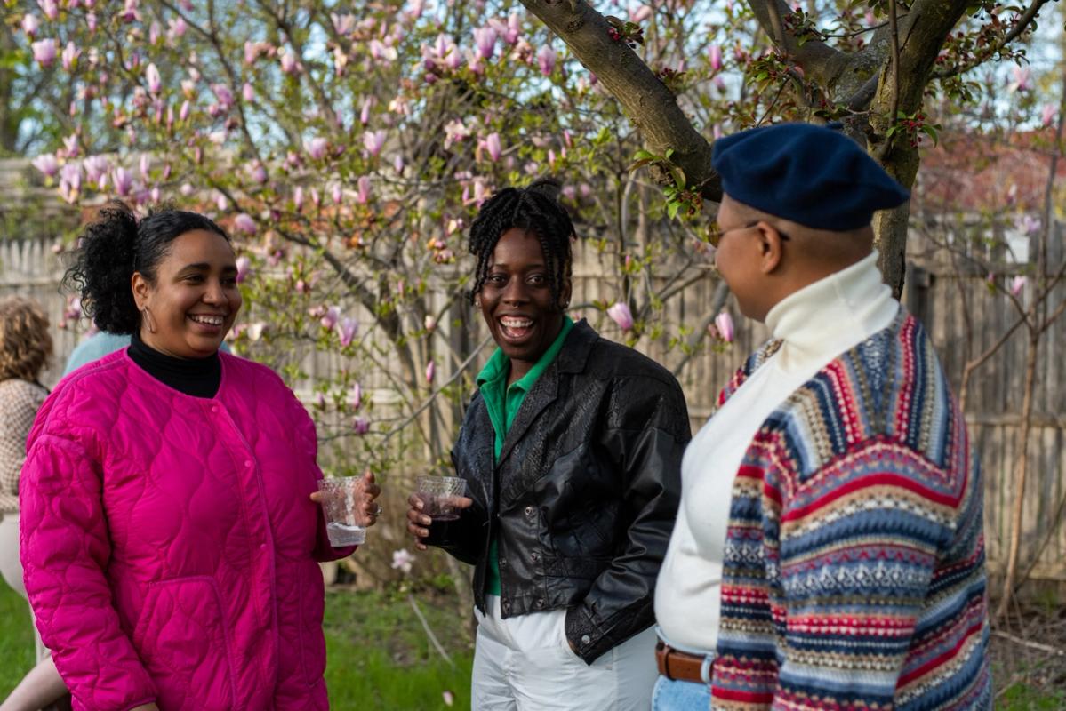 a group of people are standing next to each other in front of a tree .