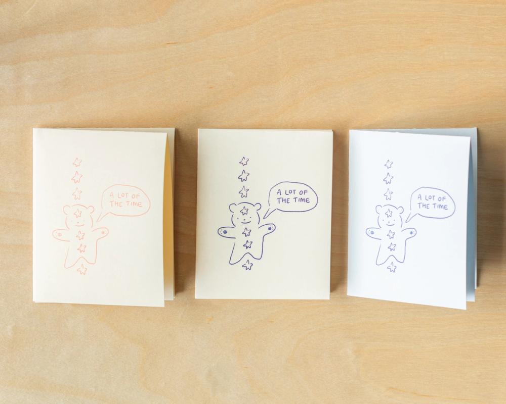 three cards with gingerbread men on them are sitting on a wooden table .