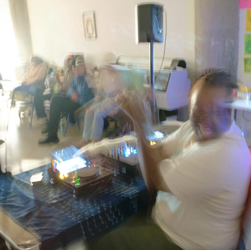 a blurry picture of a man playing using dj equipment in a room .