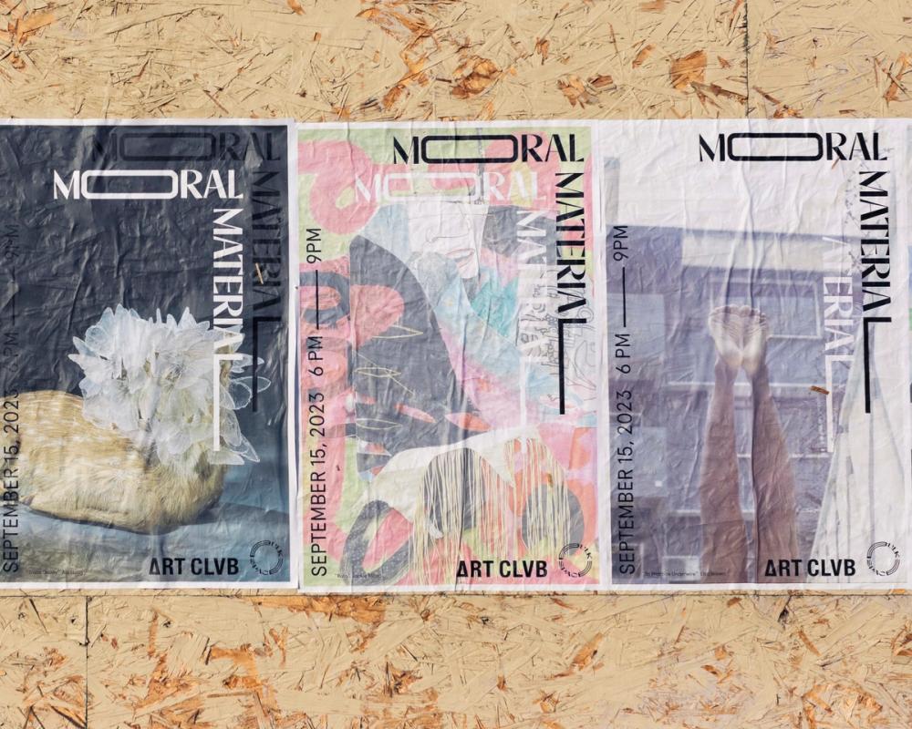 three posters are taped to a wooden wall .