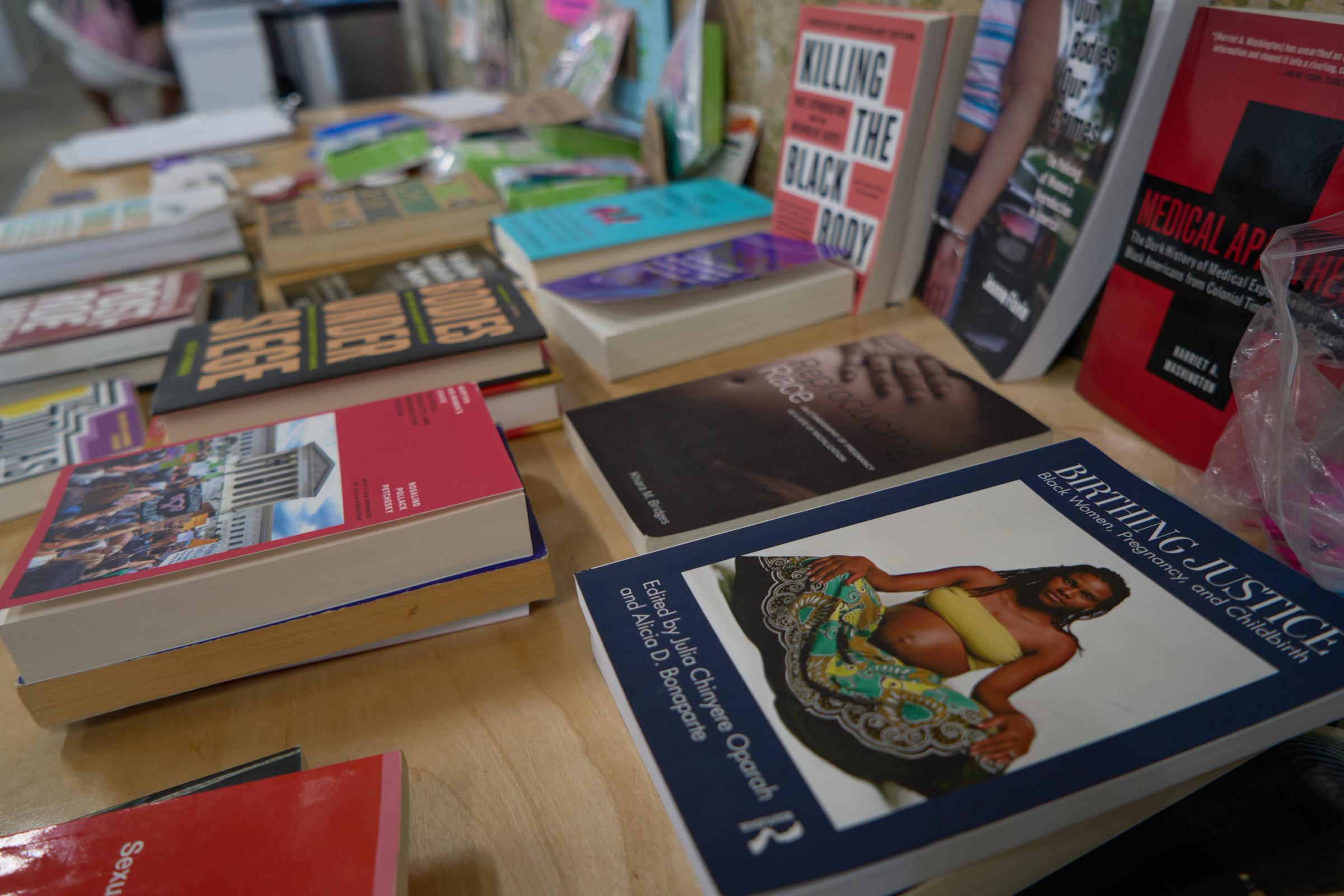 a bunch of books are stacked on top of each other on a table .
