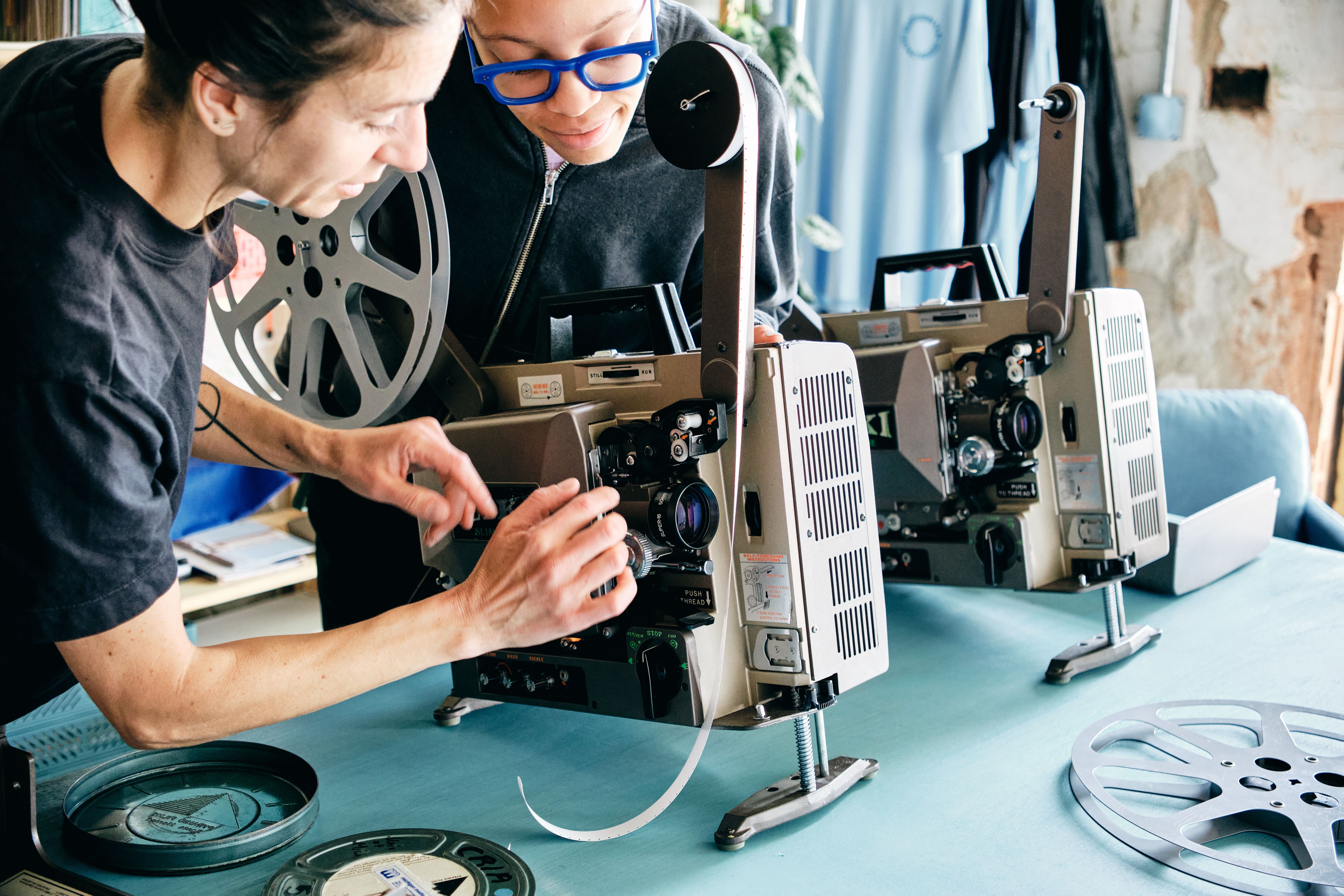 a man and a woman are working on a projector .