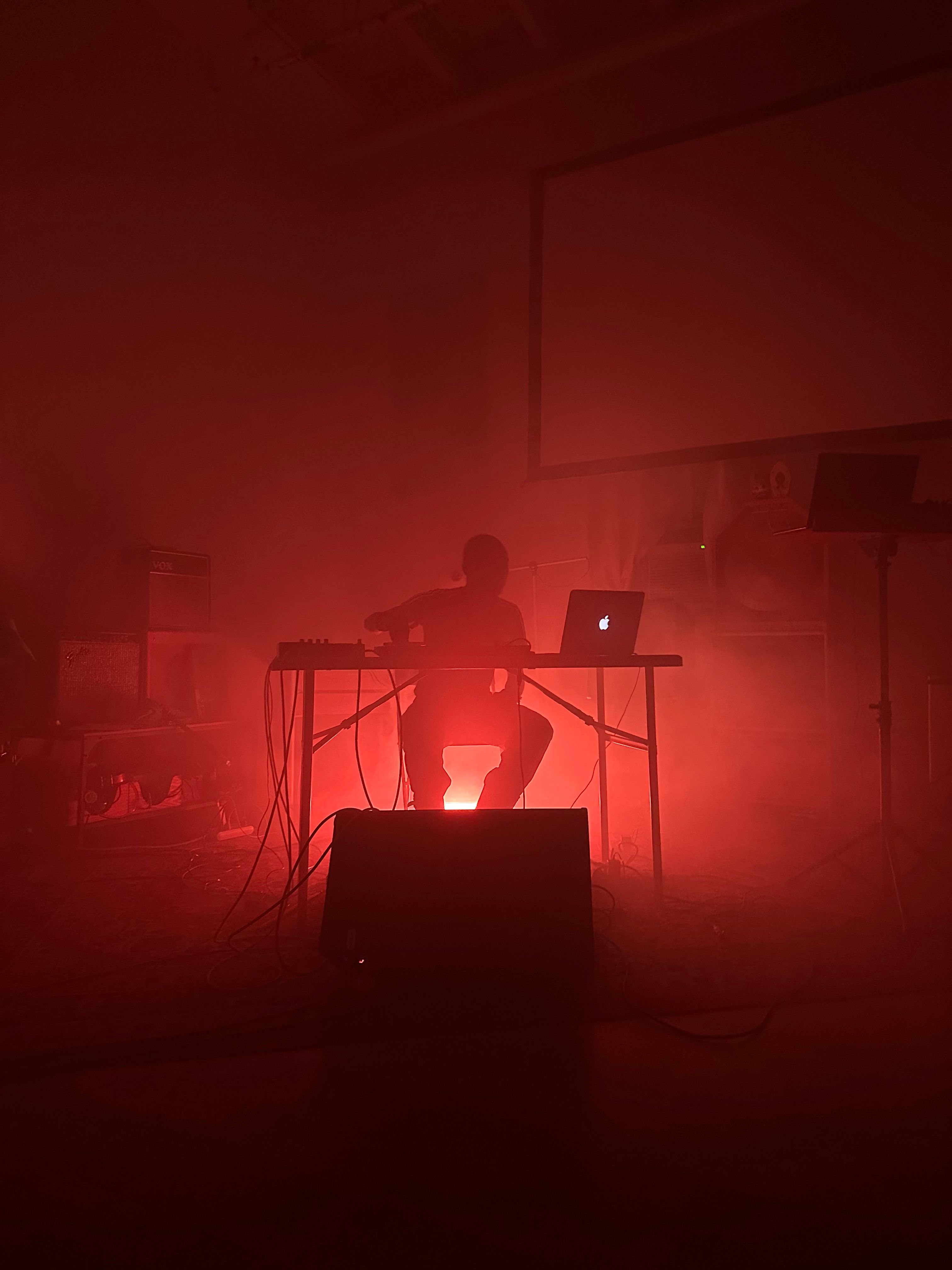 a man is sitting at a desk with a laptop in a dark room .